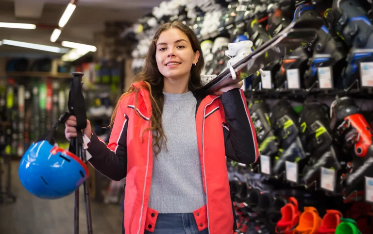 Une femme loue des skis dans un magasin de location.